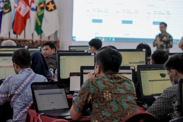 Petugas terlihat sibuk saat bertugas di ruang monitoring Sirekap di lantai 2 Kantor KPU Pusat, Jakarta, Sabtu (29/11/2024). Foto: Jamal Ramadhan/kumparan