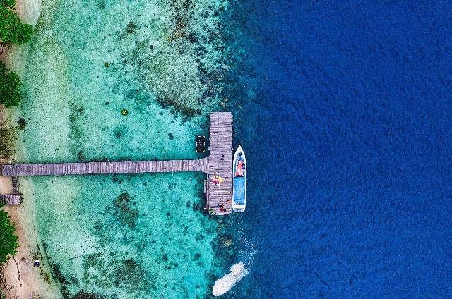 ilustrasi Pulau Seribu (sumber foto oleh Tom Fisk: https://www.pexels.com/id-id/foto/foto-udara-perahu-putih-dan-biru-di-sisi-dermaga-3531818/)