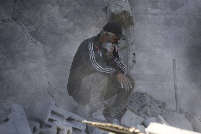 Seorang pria menutupi wajahnya saat warga Palestina mencari korban di lokasi serangan udara Israel di sebuah rumah, di tengah konflik yang sedang berlangsung antara Israel dan Hamas, di Kota Gaza, Sabtu (30/11/2024). Foto: Dawoud Abu Alkas/REUTERS