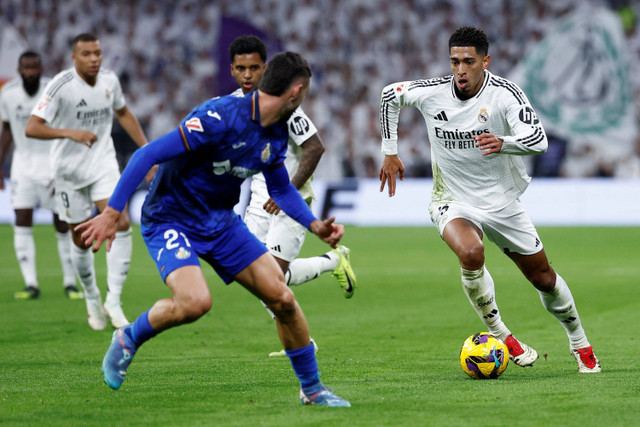 Pemain Real Madrid Jude Bellingham berusaha melewati pemain Getafe pada pertandingan Liga Spanyol di  Santiago Bernabeu, Madrid, Spanyol, Minggu (1/12/2024). Foto: Juan Medina/REUTERS