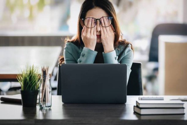 "Gambar seseorang yang merasa tertekan saat menggunakan perangkat digital, menunjukka dampak negatif teknologi terhadap kesehatan mental."Sumber: Getty Images/iStockphoto.