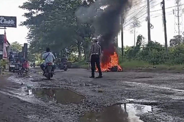 Warga bakar ban di simpang tiga Jalan Raya Kecamatan Puger, Kabupaten Jember karena jalan rusak. Foto: Dok. Istimewa