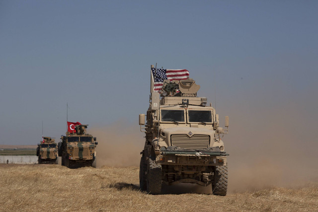 Kendaraan lapis baja Turki dan Amerika melakukan patroli gabungan pertama di "zona aman" di sisi perbatasan Suriah dengan Turki di dekat Tal Abyad, Suriah, 8 September 2019. Foto: Maya Alleruzzo/AP Photo