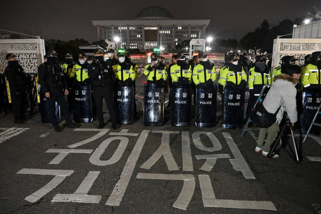 Polisi berjaga setelah Presiden Korea Selatan Yoon Suk Yeol mengumumkan darurat militer di depan gerbang utama Majelis Nasional di Seoul, Korea Selatan, Selasa (3/12/2024). Foto: JUNG YEON-JE / AFP