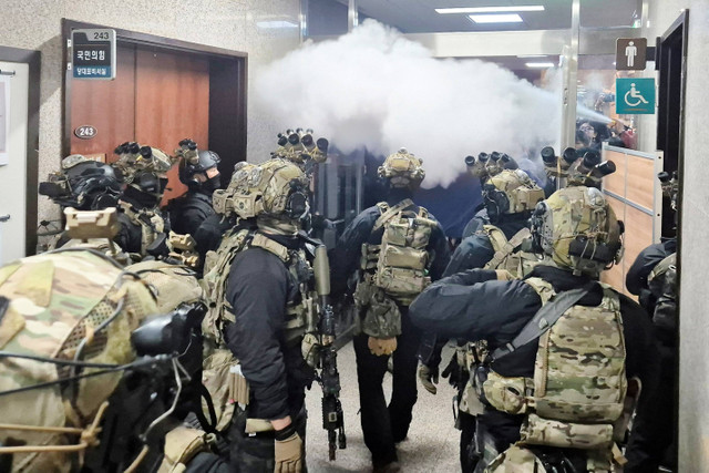 Militer memasuki gedung utama Majelis Nasional setelah Presiden Korea Selatan Yoon Suk Yeol mengumumkan darurat militer di Seoul, Korea Selatan, Selasa (3/12/2024). Foto: Yonhap/via REUTERS 