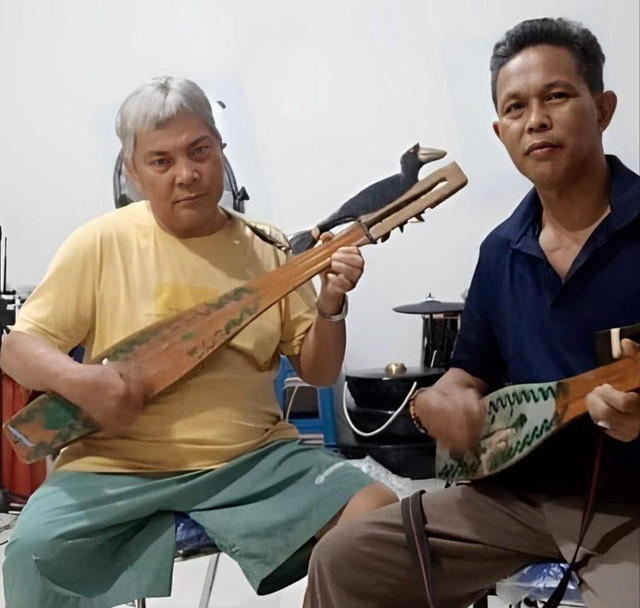 Ilustrasi foto memainkan kecapi, salah satu alat musik pengiring karungut. Sumber : Foto milik pribadi.