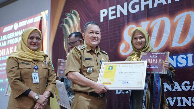 Kepala Disnakertrans Provinsi Kalimantan Barat, Drs. Hermanus M.Si menyerahkan Penghargaan Siddhakarya 2024 kepada Mashita Pemilik UMKM 101 Coffee House Binaan TJSL PLN UID Kalbar. Foto: Dok. PLN Kalbar