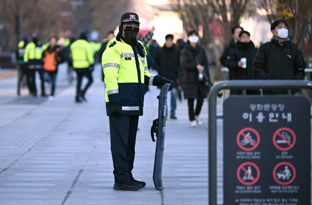 Polisi berjaga di Gwanghwamun Square di pusat kota Seoul, Korea Selatan, Rabu (4/12/2024). Foto: Jung Yeon-je / AFP