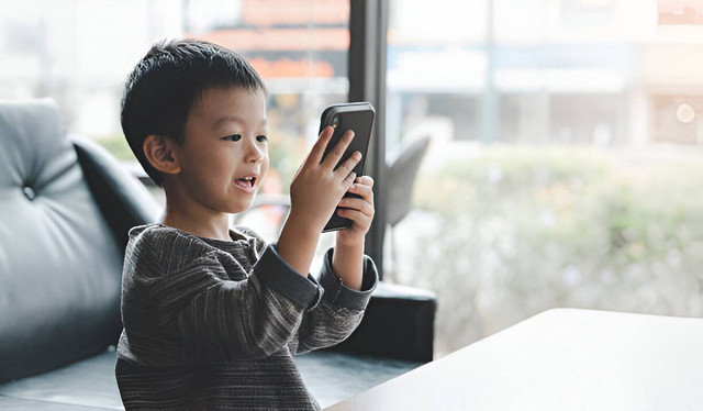 Bayi laki-laki lucu bermain game di tablet atau smartphone dan menonton kartun. (Picture from iStock)