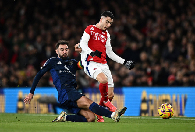 Bruno Fernandes tekel Gabriel Martinelli saat laga Arsenal vs Manchester United dalam pekan ke-14 Liga Inggris 2024/25 di Stadion Emirates, Kamis (5/12) dini hari WIB. Foto: REUTERS/Dylan Martinez