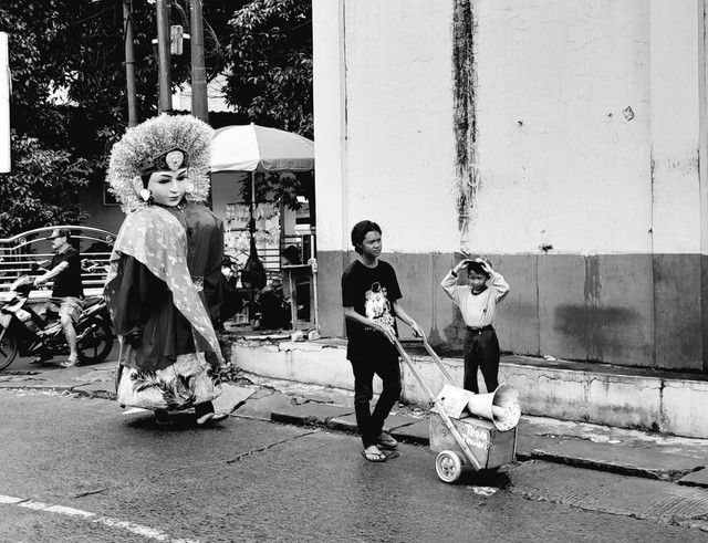 Tebem pengamen jalanan dengan membawa sebuah ondel-ondel dan mendorong sebuah gerobag musik. Rabu (4/12/2024). Pancoran Mas, Kota Depok. foto : ibnu pribadi