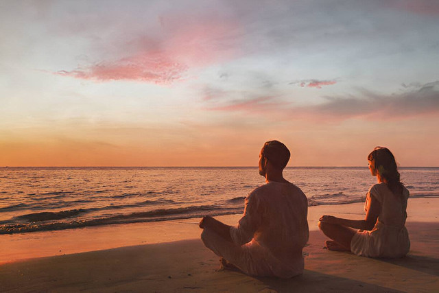 Mindfulness, pasangan melakukan yoga dan latihan pernapasan saat matahari terbenam. (Picture from iStock)