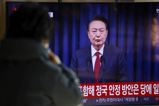 Seorang warga menyaksikan siaran Presiden Korea Selatan Yoon Suk Yeol yang menyampaikan pidato. Korea Selatan, Sabtu (7/12/2024). Foto: Kim Soo-Hyeon/REUTERS