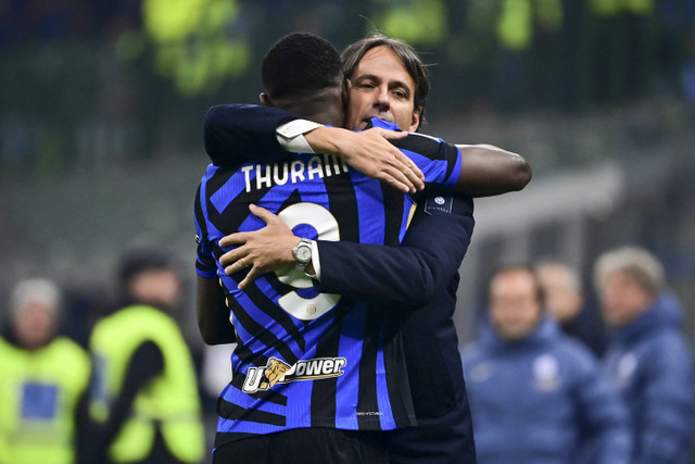 Pelatih Inter Milan Simione Inzaghi memeluk pemain Marcus Thuram usai berhasil mencetak gol ke gawang Parma pada pertandingan Serie A Liga Italia di San Siro, Milan, Italia, Jumat (6/12/2024). Foto: Piero Cruciatti/AFP