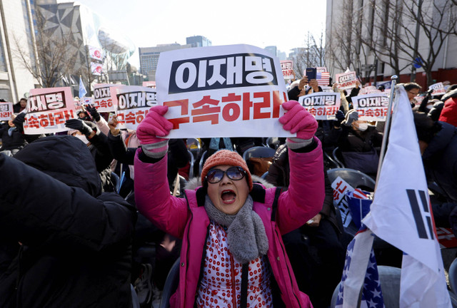 Pengunjuk rasa membentangkan poster saat mengikuti aksi  pemakzulan Presiden Korea Selatan Yoon Suk Yeol, yang mengumumkan darurat militer di Seoul, Korea Selatan, Sabtu (7/12/2024).  Foto: Kim Soo-Hyeon/REUTERS