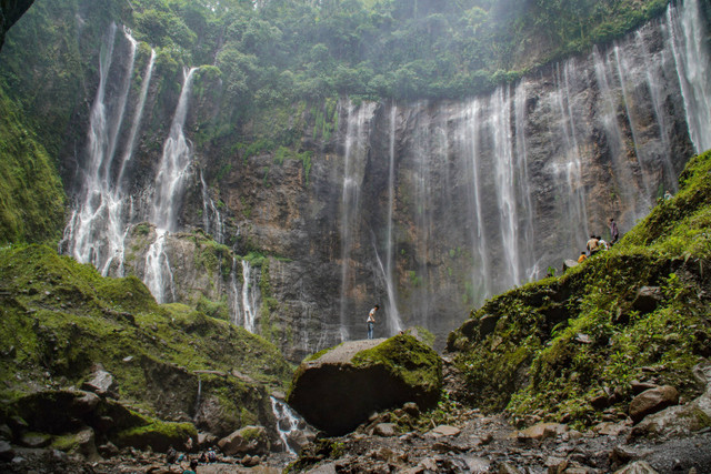 Wisatawan menyusuri sungai saat mengunjungi air terjun Tumpak Sewu di Ampelgading, Kabupaten Malang, Jawa Timur, Sabtu (7/12/2024). Foto: ANTARA FOTO/Irfan Sumanjaya