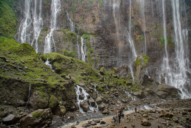 Wisatawan menyusuri sungai saat mengunjungi air terjun Tumpak Sewu di Ampelgading, Kabupaten Malang, Jawa Timur, Sabtu (7/12/2024). Foto: ANTARA FOTO/Irfan Sumanjaya