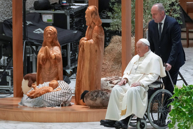 Paus Fransiskus berdoa di depan Kandang Natal yang berada di aula Paulus VI, Vatikan, Sabtu (7/12/2024). Foto: Andrew Medichini/AP Photo