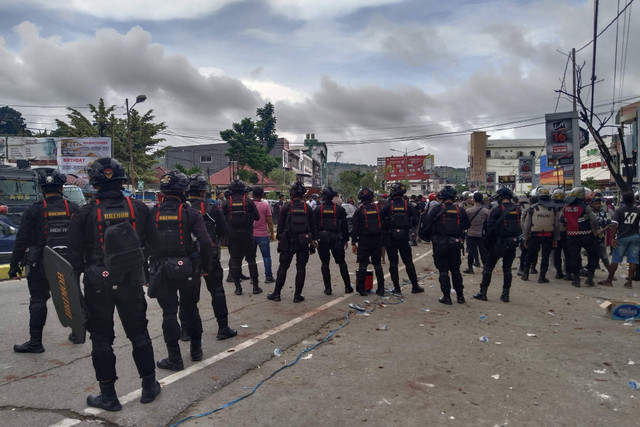 Polisi berjaga usai bentrok antar-dua kubu paslon Cawalkot-Wawalkot Jayapura, di depan Hotel Grand Abe, Distrik Abepura, Kota Jayapura, Jumat sore (6/12/2024). Foto: Polda Papua