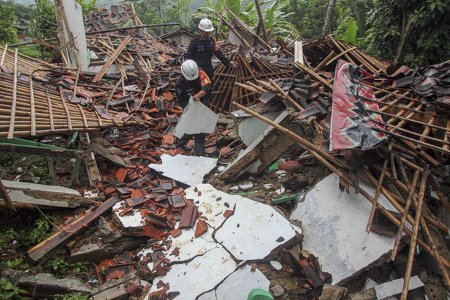 Petugas SAR Brimob merapikan material dampak pergeseran tanah di Kampung Cihonje, Desa Sukamaju, Kecamatan Cikembar, Sukabumi, Jawa Barat, Senin (9/12/2024). Foto: Yulius Satria Wijaya/ANTARA FOTO