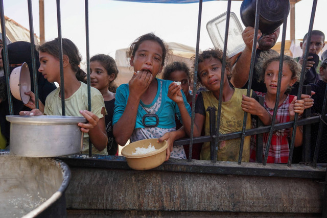 Warga Palestina menerima jatah makanan matang sebagai bagian dari inisiatif sukarelawan di kamp pengungsian sementara di Mawasi Khan Yunis di Jalur Gaza, pada 3 September 2024. Foto: Bashar Taleb/AFP