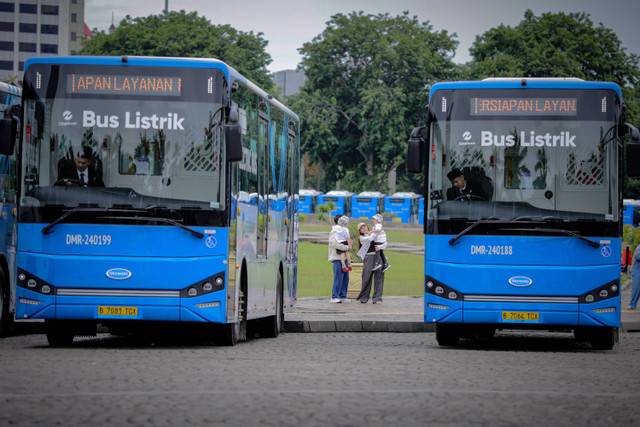 Pengunjung melihat bus listrik Transjakarta berjejer di kawasan Monumen Nasional, Jakarta, Selasa (10/12/2024). Foto: Jamal Ramadhan/kumparan