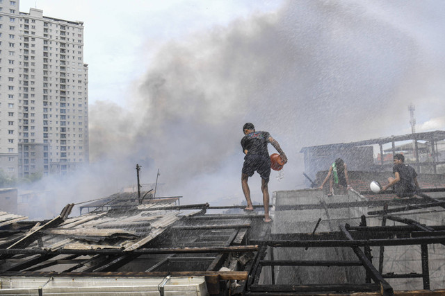 Warga berusaha memadamkan api yang membakar permukiman padat penduduk di kawasan Kebon Kosong, Kemayoran, Jakarta, Selasa (10/12/2024). Foto: Muhammad Adimaja/ANTARA FOTO