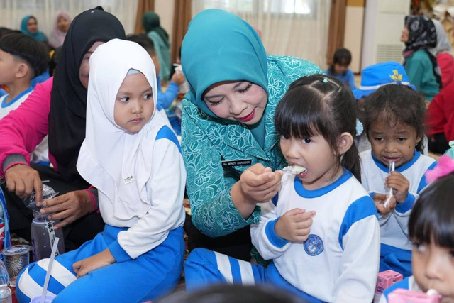 Ketua TP PKK Kalbar, Windy Prihastari menyuapkan makanan pada saat melakukan uji coba makan bergizi gratis. Foto: Dok. Pemprov Kalbar