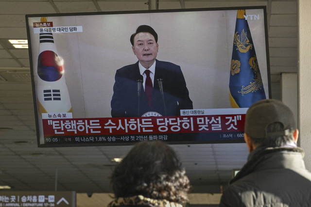 Sebuah layar menunjukkan Presiden Korea Selatan Yoon Suk Yeol berbicara dalam pidato yang disiarkan di televisi di terminal bus di Seoul pada 12 Desember 2024. Foto: Anthony Wallace/AFP