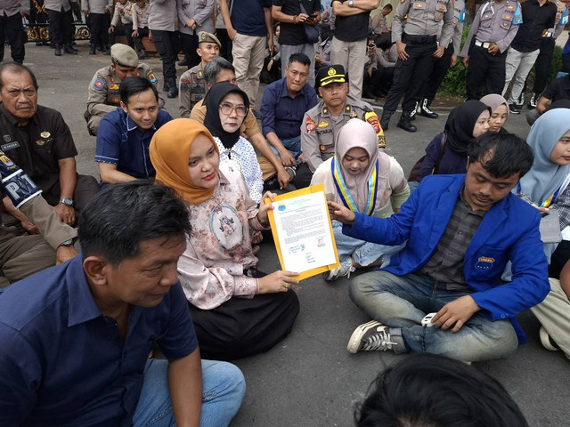 Ketua DPRD Kabupaten Cirebon, Sophi Zulfia, saat menunjukkan tanda tangan persetujuannya yang menerima segala bentuk tuntutan para pengunjuk rasa. Foto: Tarjoni/Ciremaitoday