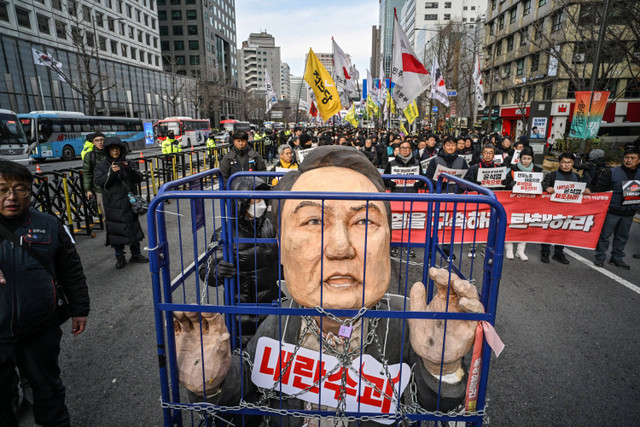 Demonstran dari kelompok buruh mengambil bagian dalam protes yang menyerukan penggulingan Presiden Korea Selatan Yoon Suk Yeol di luar Balai Kota di Seoul, Korea Selatan, Kamis (12/12/2024). Foto: ANTHONY WALLACE / AFP