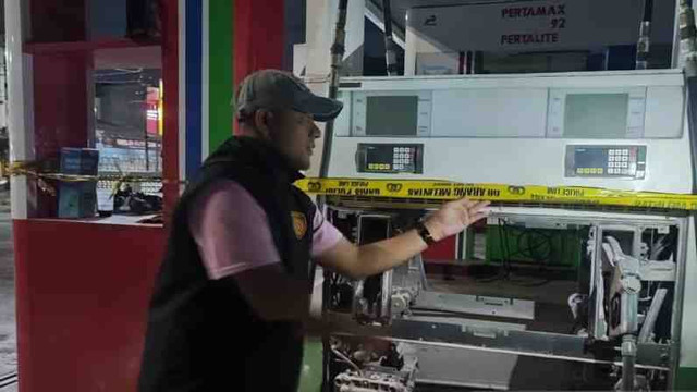 Salah satu petugas Polsek Duren Sawit tengah melakukan pemeriksaan mesin pompa atau dispenser yang meledak di SPBU Pertamina di Jalan Pahlawan Revolusi, Kelurahan Pondok Bambu, Duren Sawit, Jakarta Timur, Kamis malam (12/12/2024). Foto: ANTARA/Syaiful Hakim