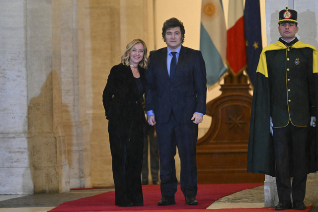 Perdana Menteri Italia, Giorgia Meloni (kiri) menyambut Presiden Argentina, Javier Milei (kanan) di Palazzo Chigi sebelum pertemuan mereka di Roma pada 13 Desember 2024. Foto: Andreas Solaro/AFP