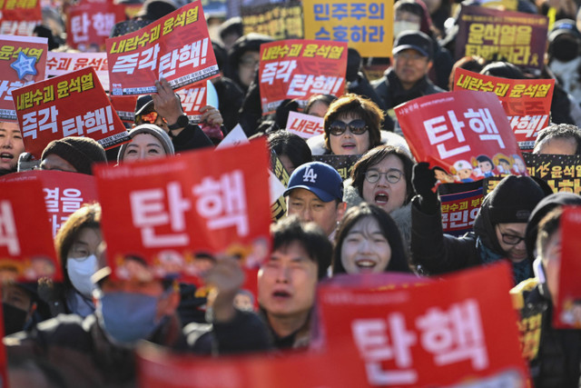 Sejumlah pengunjuk rasa mengikuti aksi penggulingan Presiden Korea Selatan Yoon Suk Yeol di Seoul, Korea Selatan, Sabtu (14/12/2024). Foto: Jung Yeon-je/AFP