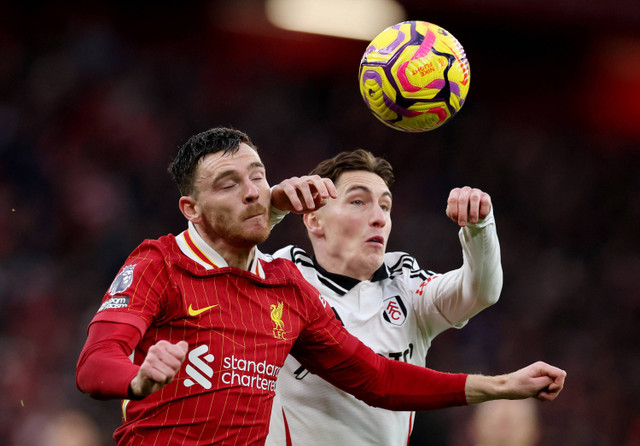 Andrew Robertson dari Liverpool berebut bola dengan Harry Wilson dari Fulham pada Liga Premier di Anfield, Liverpool, Inggris, 14 Desember 2024. Foto: REUTERS/Phil Noble