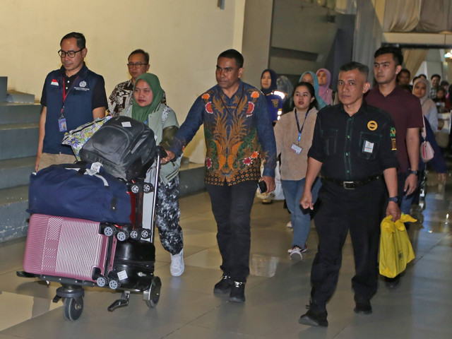 Sejumlah warga negara Indonesia (WNI) didampingi Direktur Perlindungan WNI Judha Nugraha (kiri) berjalan keluar terminal setibanya dari Suriah di Terminal 3 Bandara Soekarno-Hatta, Tangerang, Banten, Minggu (15/12/2024). Foto: Muhammad Iqbal/ANTARA FOTO