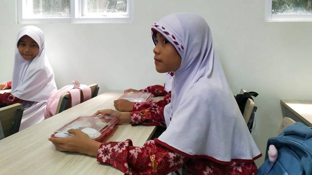 Seorang siswa Sekolah Dasar di Kota Manado, Sulawesi Utara, menerima paket makan siang dari program makan bergizi gratis.