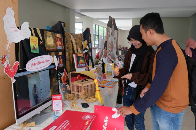 Mahasiswa ITS yang mengunjungi salah satu booth yang manampilkan desain konten promosi komunitas peternak ayam. Foto: Humas ITS