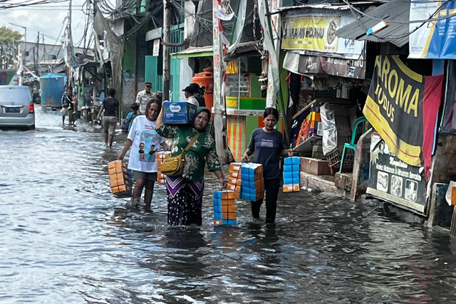 Warga berjalan melewati banjir rob di Muara Angke, Penjaringan, Jakarta Utara, Rabu (18/12/2024). Foto: Rayyan Farhansyah/kumparan