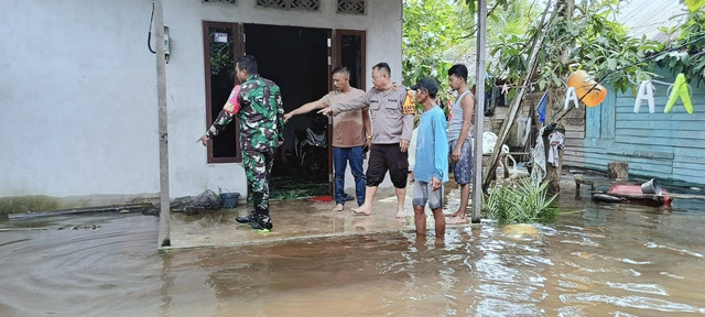 Polisi bersama warga melihat lokasi kejadian balita tercebur di genangan. Foto: Dok. Istimewa