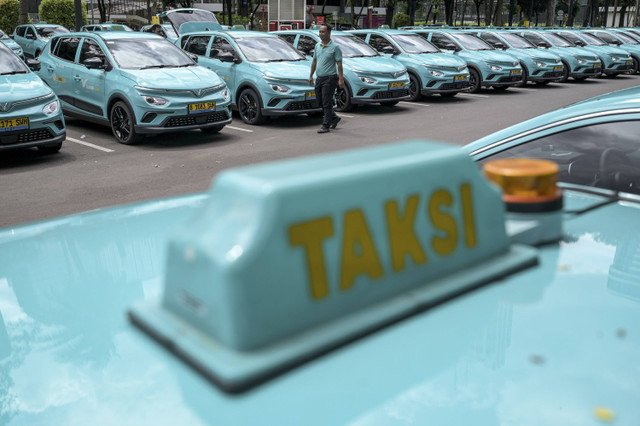 Seorang pengemudi berjalan di depan taksi Xanh SM yang terparkir saat peluncuran di Jakarta, Rabu (18/12/2024). Foto: Fauzan/ANTARA FOTO