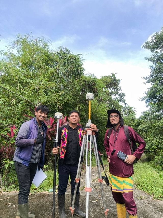 Pegawai Kantah Sekadau mengenakan pakaian adat saat melakukan pengukuran tanah di Desa Sungai Ringin. Foto: Dok. Kantah Sekadau