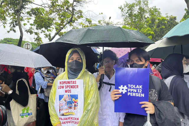 Pengunjuk rasa membentangkan poster saat aksi tolak ppn 12% di Jakarta, Kamis (19/12/2024). Foto: Rayyan Farhansyah/kumparan