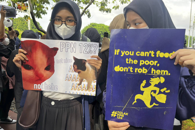 Pengunjuk rasa membentangkan poster saat aksi tolak ppn 12% di Jakarta, Kamis (19/12/2024). Foto: Rayyan Farhansyah/kumparan