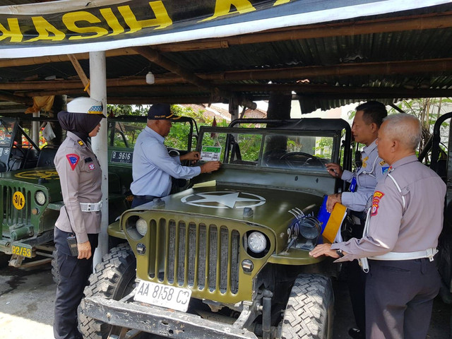 Petugas saat menempelkan stiker di jip wisata di Sleman. Foto: Dok. Dishub Sleman