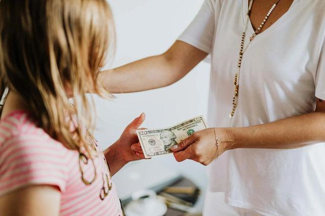 Anak menerima uang dari orang tuanya (https://www.pexels.com/photo/woman-giving-10-dollars-to-a-girl-4968392/)