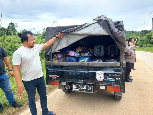 Polisi menunjukan barang bukti BBM illegal yang diungkap anggota Polsek Batu Sopang, Paser, Kalimantan Timur. Foto: Instagram/@polsek_batu_sopang