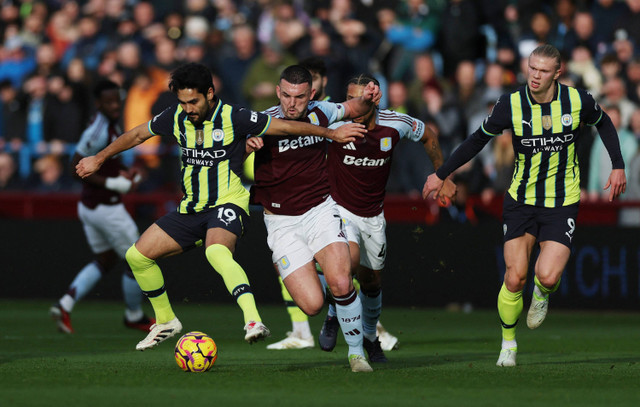 Ilkay Gundogan dari Manchester City berebut bola dengan John McGinn dari Aston Villa pada Liga Premier di Villa Park, Birmingham, Inggris, 21 Desember 2024. Foto: Reuters/Lee Smith