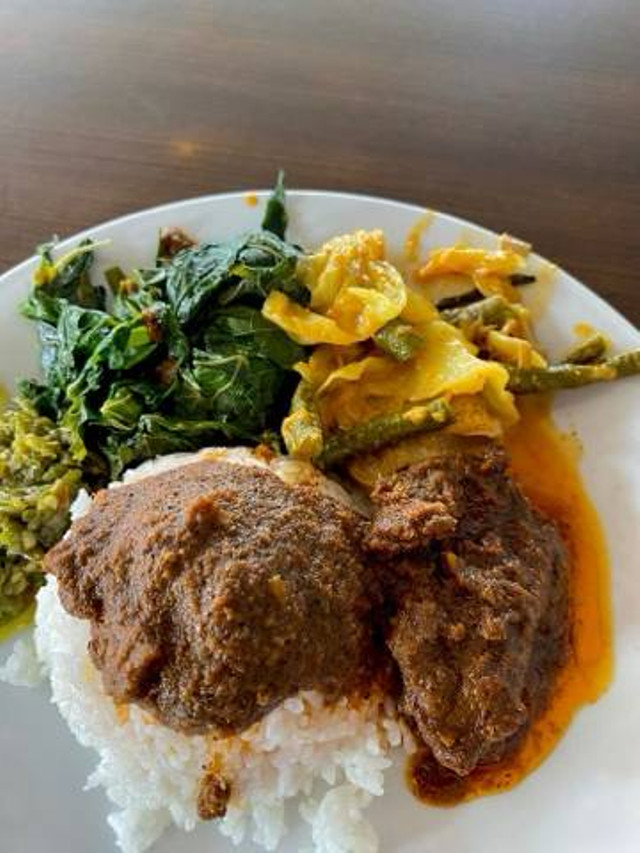 Foto ini menampilkan sepiring nasi Padang dengan lauk rendang dan sayur. Potongan daging rendang yang empuk dan kaya rempah berpadu dengan kuah santan kental yang menggoda. Di sampingnya, terdapat sayur yang segar, menambah keseimbangan rasa gurih dan pedas dalam hidangan khas Minangkabau ini, sumber: foto pribadi 