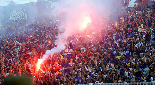 Ilustrasi suporter sepak bola Indonesia yang menggelora, foto suporter Arema di Gajayana Stadium Malang (Foto : dodohawe / unsplash)